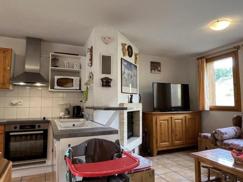 une cuisine avec une poussette rouge dans l'établissement Chalet ensoleillé sur pistes, 5 chambres, animaux admis - FR-1-351-82, à Plagne Villages