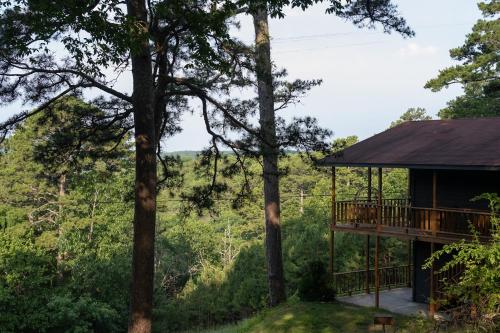 a tree house with a deck in the woods at The Woodsman Lodge in Eureka Springs