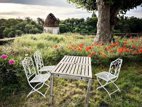 a picnic table and two chairs in a field of flowers at La Tour Beurdelaine in Avallon