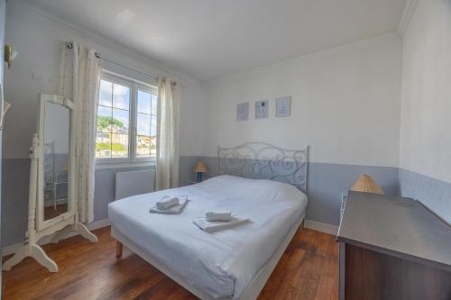 a bedroom with a bed with two towels on it at Le Bassin in Port-en-Bessin-Huppain