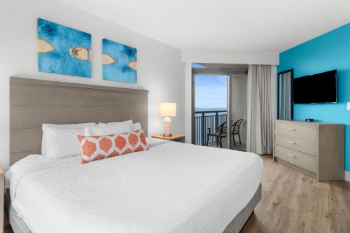 a bedroom with a white bed and a view of the ocean at Caribbean Resort Myrtle Beach in Myrtle Beach