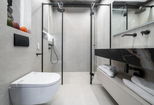 a bathroom with a toilet and a glass shower at Apartament INCOGNITO PREMIUM & SPA in Białka Tatrzanska