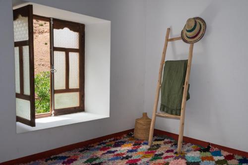 a room with a ladder and a rug and a window at Auberge Sremt in Sremt