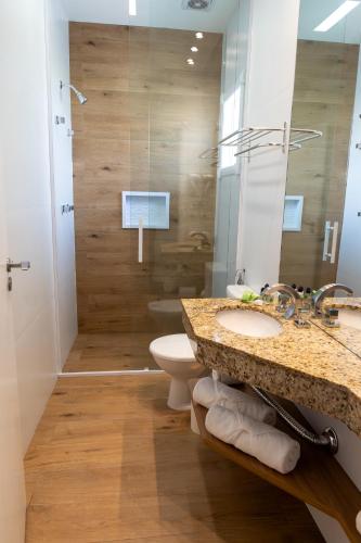 a bathroom with a sink and a toilet and a shower at Pousada Nacional Inn Campos do Jordão in Campos do Jordão