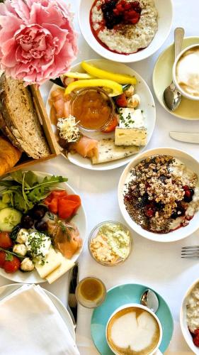 a table with many plates of food on it at THE NIXON Luxury Suites and Apartment Hotel in Athens