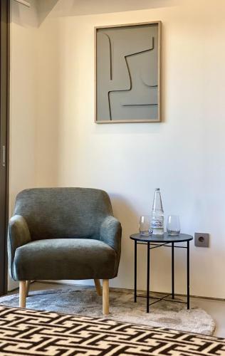 a living room with a chair and a table at THE NIXON Luxury Suites and Apartment Hotel in Athens