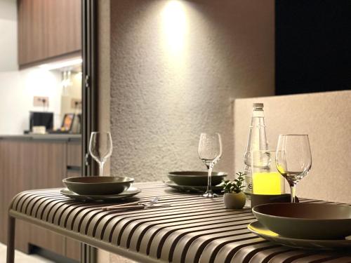 a table with plates and wine glasses on it at THE NIXON Luxury Suites and Apartment Hotel in Athens