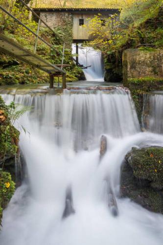 a waterfall with a bench on top of it at Apartamento Larrazu II Agroturismo Baztán in Arráyoz
