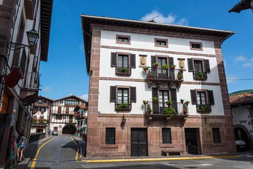 a tall brick building with flower boxes on it at Apartamento Larrazu II Agroturismo Baztán in Arráyoz