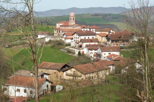 a village with a church on top of a hill at Apartamento Larrazu II Agroturismo Baztán in Arráyoz