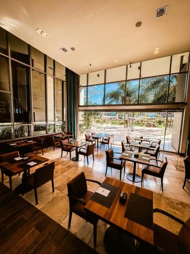a restaurant with tables and chairs and a large window at Los Silos Hotel in Santa Fe