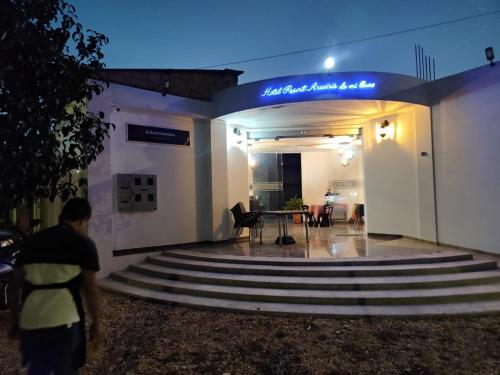 a man standing in front of a building at night at HOTEL EMPRESARIAL Arcoiris de mi llano in Paz de Ariporo