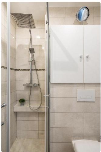 une douche avec une porte vitrée dans une salle de bain dans l'établissement Chambre Double avec Salle de Bains Commune, à Lyon