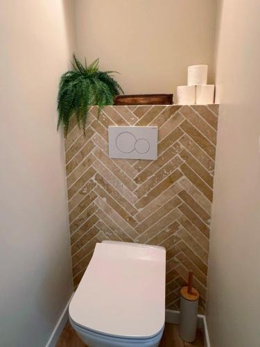 La salle de bains est pourvue de toilettes et d'un mur en briques. dans l'établissement Superbe 3 chambres au centre d'Antibes AC, Parking, WIFI, à Antibes