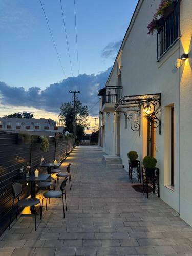 a patio with tables and chairs next to a building at Garni Hotel Maggitti in Velika Plana