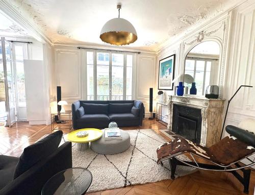 uma sala de estar com um sofá e uma lareira em Comme une maison à deux pas de l'Arc de Triomphe em Paris