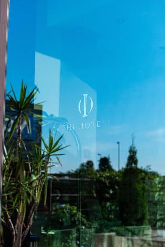 a glass window of a building with a palm tree at Phi Hotel Milano in Baranzate