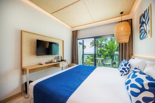 a bedroom with a blue bed and a window at Marins Suites - Adults Only Hotel in Cala Millor