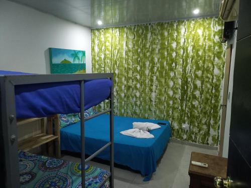 1 dormitorio con litera y cortina en Casa alojamiento las acacias, en Santa Marta