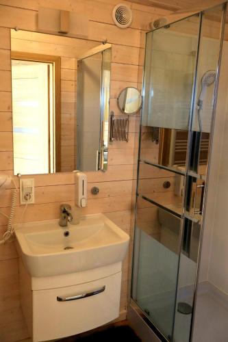 a bathroom with a sink and a glass shower at Rainbow Resort in Jastrzębia Góra