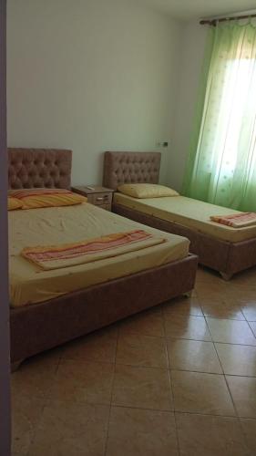 two beds are sitting in a room with at Villa Kalaj in Baks-Rrjoll