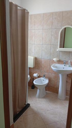 a bathroom with a sink and a toilet and a mirror at Villa Kalaj in Baks-Rrjoll
