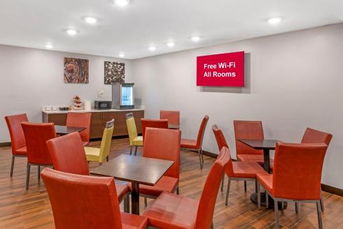 a waiting room with tables and chairs and a counter at Red Roof PLUS Brooklyn - 3rd Ave in Brooklyn