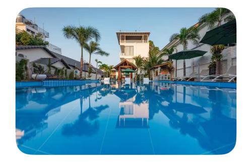a large swimming pool with blue water and palm trees at Villa caribe phu quoc in Phu Quoc