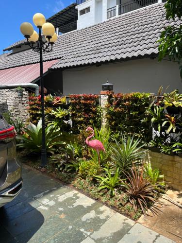 a pink flamingo in a garden in front of a house at Villa caribe phu quoc in Phu Quoc
