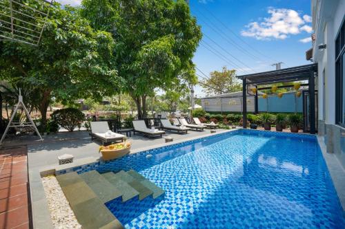 una piscina con sillas y una casa en Hoi An Beachfront Hotel, en Hoi An