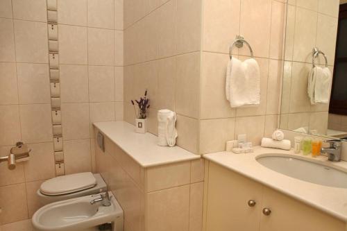 une salle de bain blanche avec toilettes et lavabo dans l'établissement Aphrodite Hills Superior Villas Superior Villa 0066 Air Conditioning, à Paphos