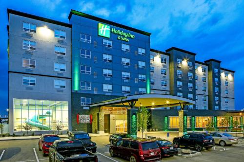 a hotel with cars parked in a parking lot at Holiday Inn Hotel & Suites - Calgary Airport North by IHG in Calgary