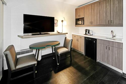 a kitchen with a small table and chairs in a room at Holiday Inn Hotel & Suites - Calgary Airport North by IHG in Calgary