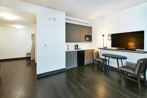 a room with a kitchen and a table with chairs at Holiday Inn Hotel & Suites - Calgary Airport North by IHG in Calgary