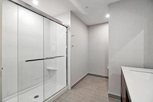 a glass shower in a bathroom with a sink at Holiday Inn Hotel & Suites - Calgary Airport North by IHG in Calgary