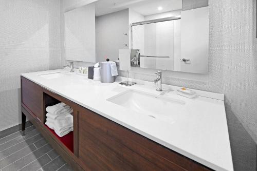 a bathroom with two sinks and a large mirror at Holiday Inn Hotel & Suites - Calgary Airport North by IHG in Calgary