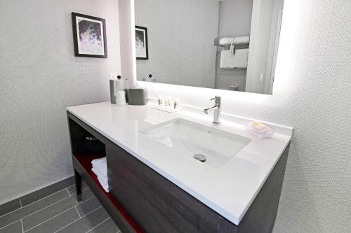 a bathroom with a white sink and a mirror at Holiday Inn Hotel & Suites - Calgary Airport North by IHG in Calgary