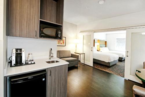a kitchen and living room in a hotel room at Holiday Inn Hotel & Suites - Calgary Airport North by IHG in Calgary