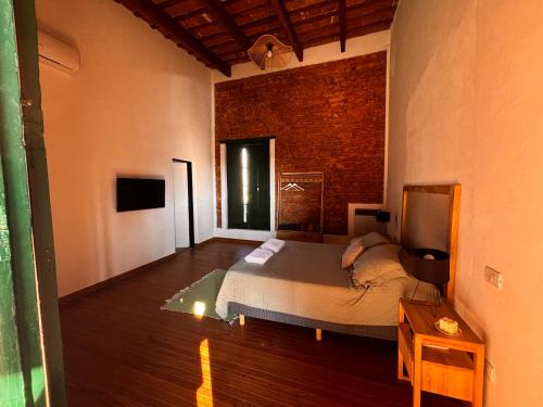 a bedroom with a bed and a brick wall at La Arequera in San Antonio de Areco