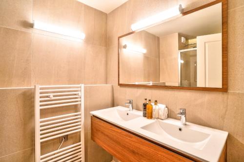 une salle de bain avec un lavabo et un miroir dans l'établissement 132 - Urban Beautiful Montorgueil, à Paris