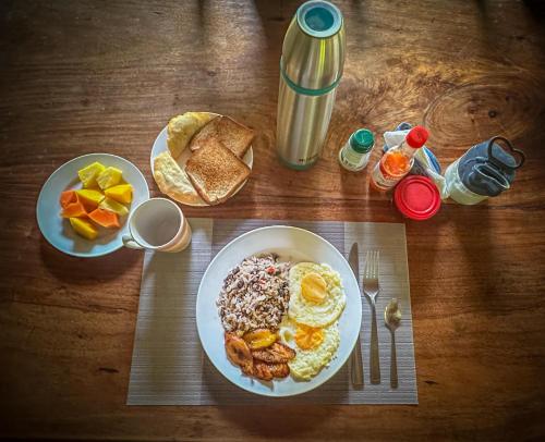 a wooden table with a plate of breakfast food at Ventanas en Corcovado in Dos Brazos