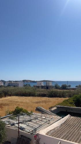 a view of a building with the ocean in the background at Syros Rooms & Apartments in Posidhonía