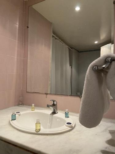 a bathroom with a sink and a large mirror at Golf Residence- Families and Couples Only in Hammam Sousse