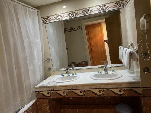 a bathroom with two sinks and a large mirror at Golf Residence- Families and Couples Only in Hammam Sousse