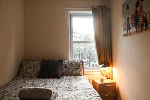 a bedroom with a bed and a window at Three Bedrooms Flat in Central Edinburgh Old Town in Edinburgh