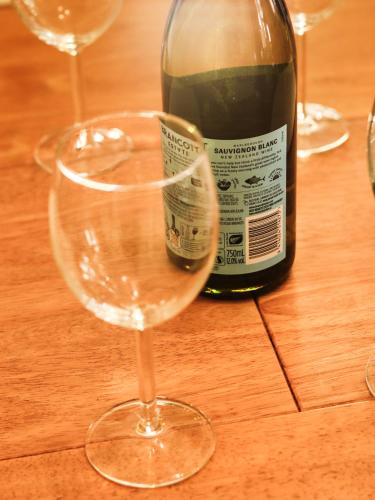 three wine glasses sitting on a table with a bottle of wine at Three Bedrooms Flat in Central Edinburgh Old Town in Edinburgh