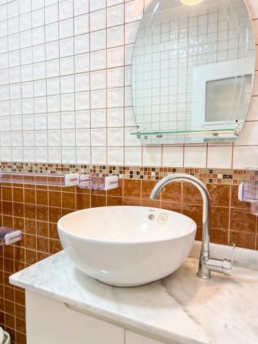 a bathroom with a white sink and a mirror at Appart-hôtel Costa Azul - Solarium in Oued Laou