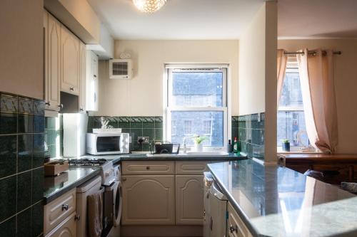 a kitchen with a sink and a stove top oven at Three Bedrooms Flat in Central Edinburgh Old Town in Edinburgh