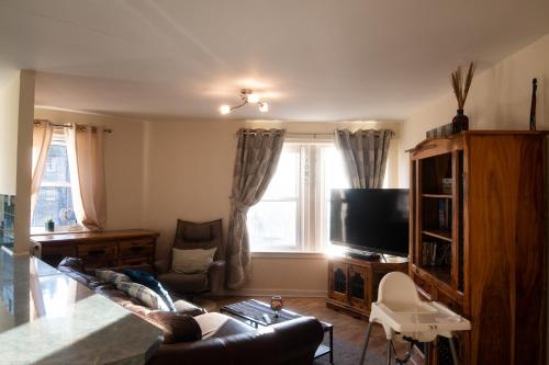 a living room with a couch and a tv at Three Bedrooms Flat in Central Edinburgh Old Town in Edinburgh