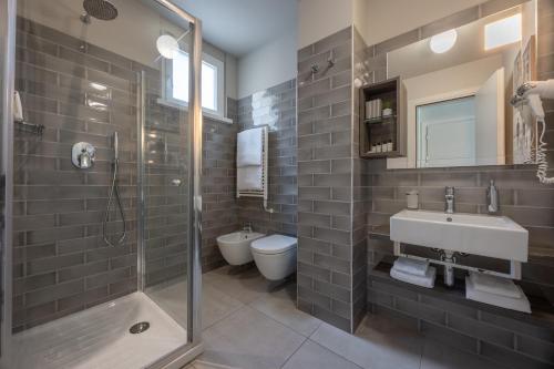 a bathroom with a shower and a sink and a toilet at Nautilus Family Hotel in Pesaro